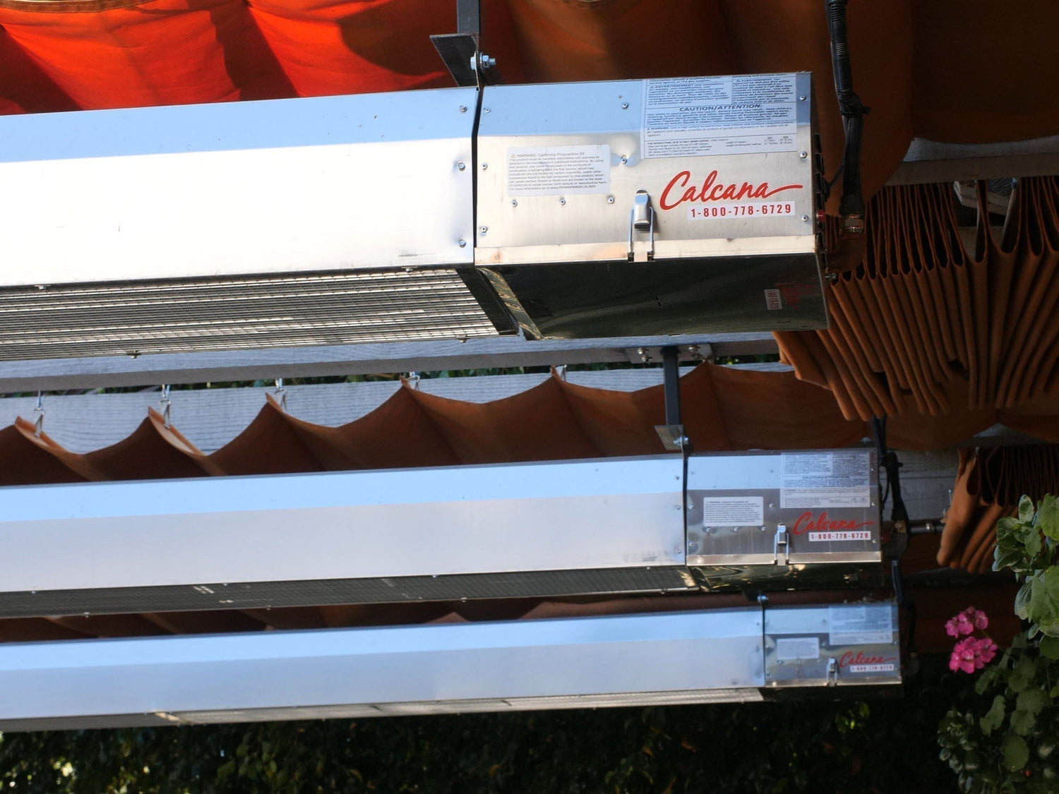Ceiling-mounted infrared overhead patio heater installed above a cozy outdoor dining space with furniture arranged beneath
