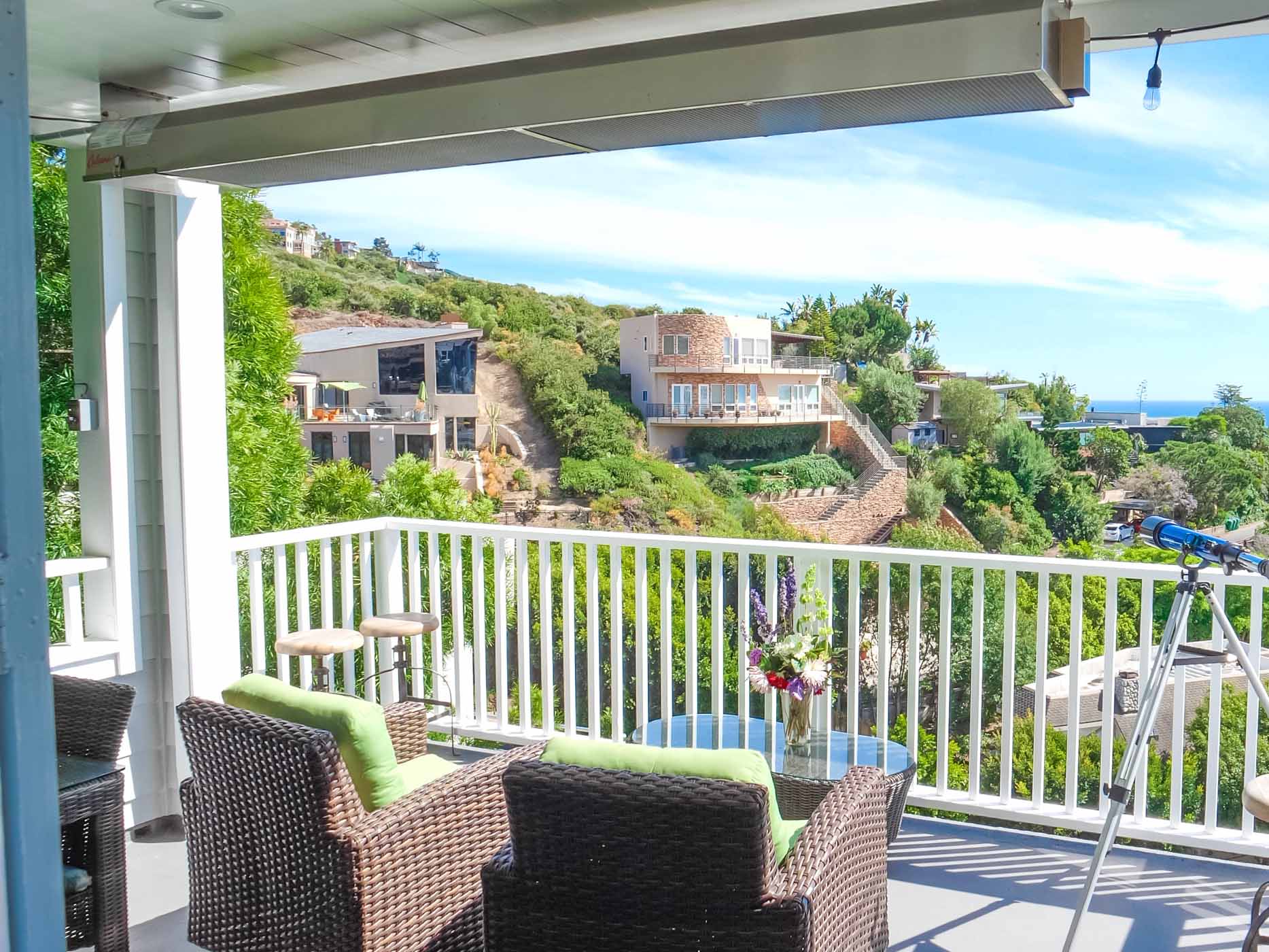 Modern patio with a mounted infrared heater and seating area, providing year-round warmth and comfort in a residential setting.