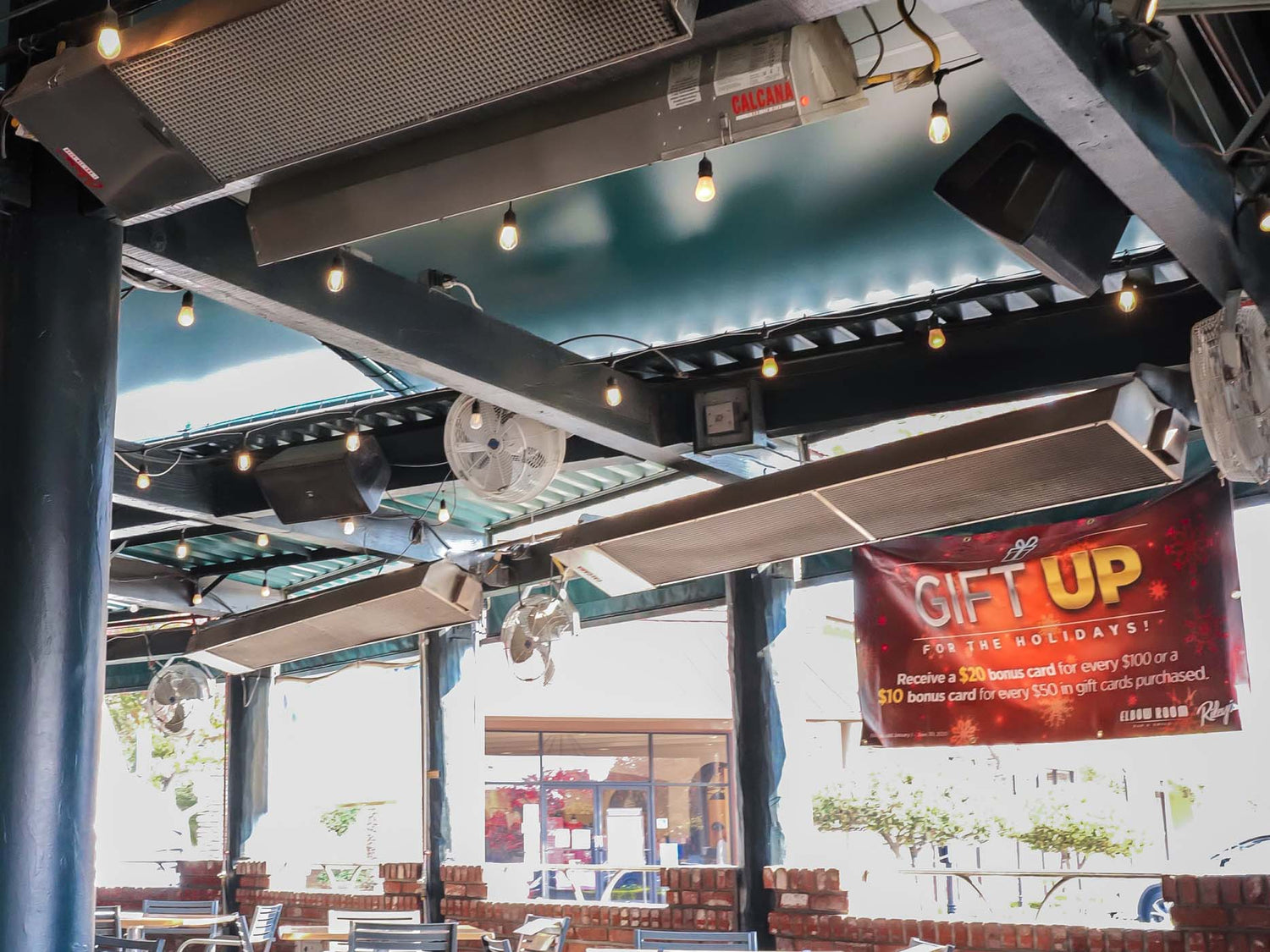 Infrared patio heater mounted overhead warming an outdoor dining space