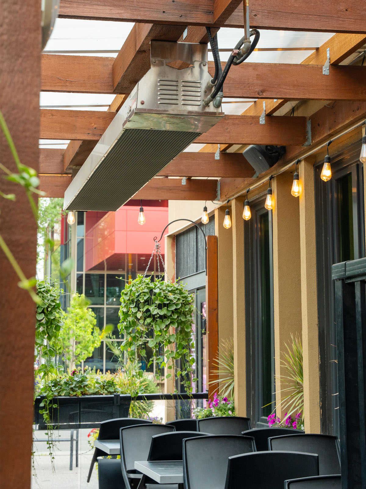 Infrared Patio Heater Single Unit Above Black Chairs & Greenery