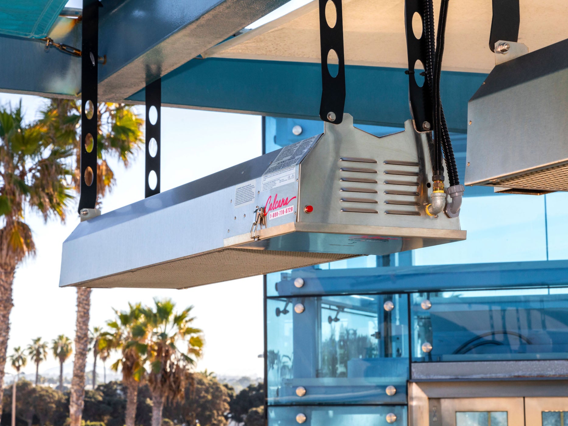 Infrared patio heater with palm trees in the background
