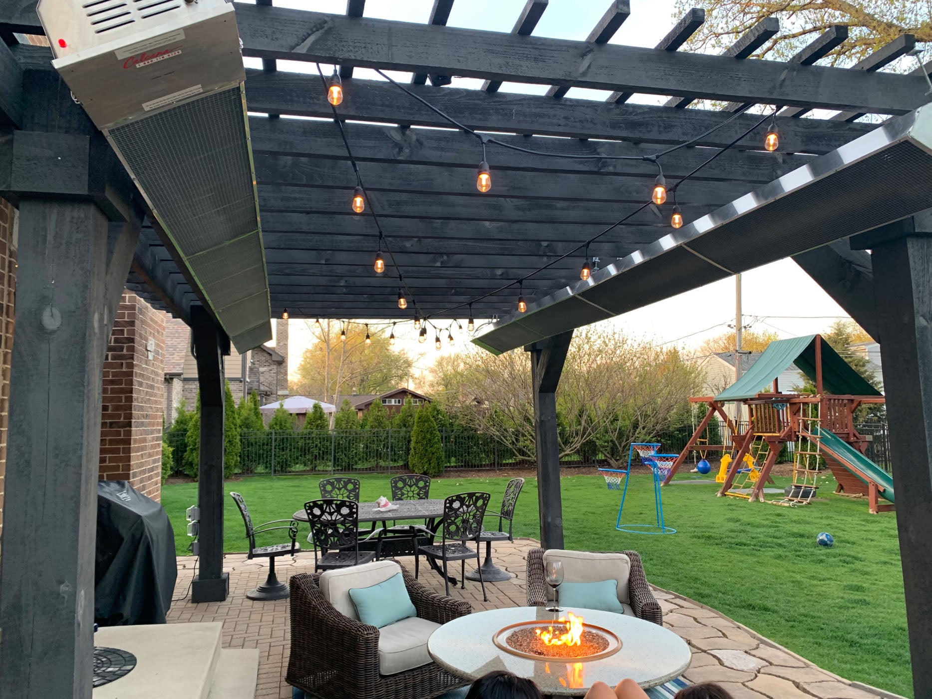 Infrared Patio Heaters Long Units Above Lounging Chairs in Backyard
