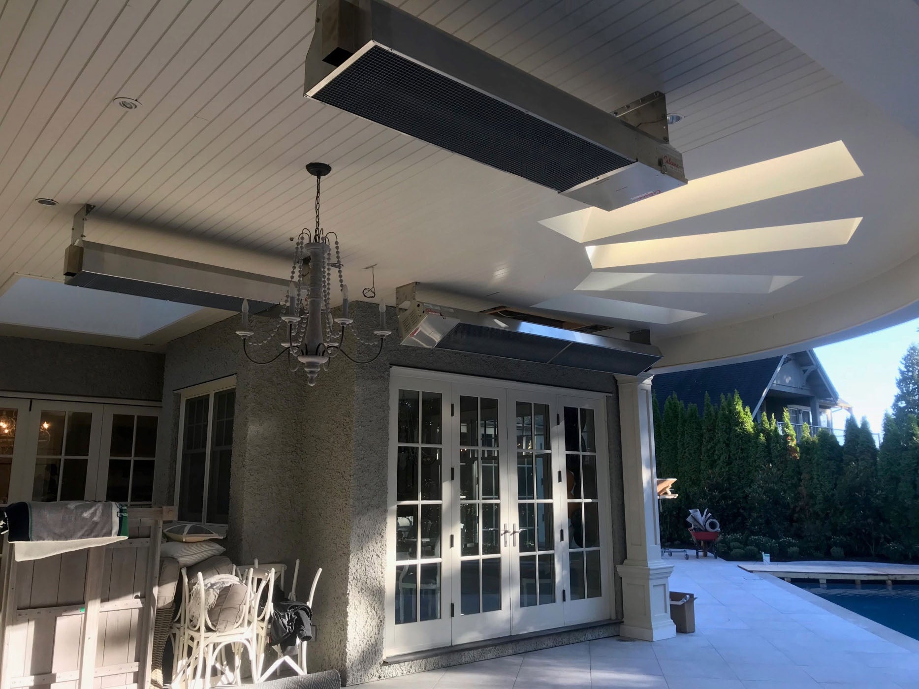 Three Infrared Patio Heaters Above Patio & Pool in Background